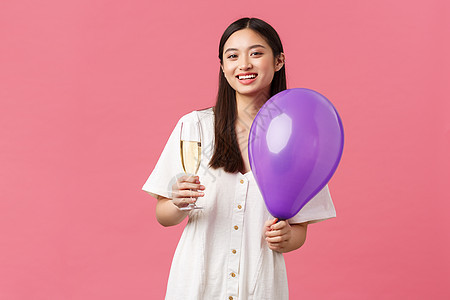 欢庆 派对节假日和娱乐概念 穿白裙子的漂亮亚洲美女 拿着气球和香槟杯 在活动期间做吐司 享受时刻 粉红背景 庆祝 喝图片