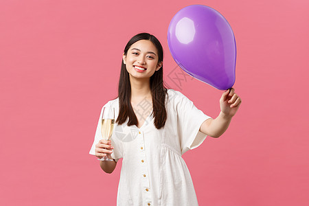 庆祝 派对节假日和娱乐概念 穿白裙子的漂亮亚洲女性 拿着气球和香槟杯 在活动期间敬酒 祝贺主办者 粉红背景等图片
