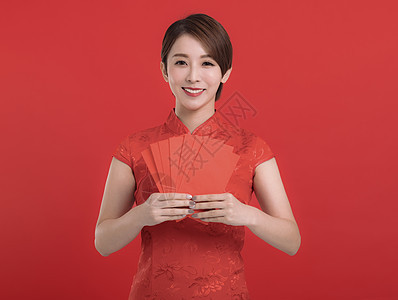 中国新年快乐 年轻女人拿着红衣信封走运图片