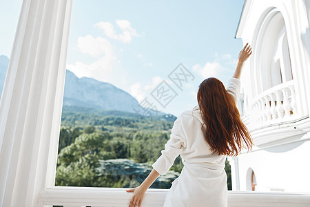 女人的白袍仰慕从窗口后视图中看到的风景图片