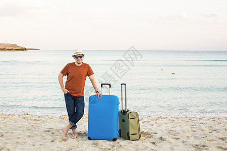 夏日阳光明媚的白天 在海面上携带行李的戴太阳眼镜和帽子的人图片