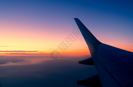 日出天际线的飞机机翼 飞机在天上飞 从飞机窗口的风景 商业航空公司航班 云层之上的飞机机翼 国际航班 covid-19 后出国旅图片