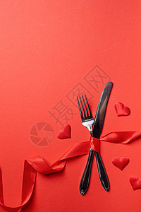 用红底的心率 与红色丝带绑在一起的叉子和刀 美丽的图片