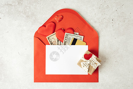 红纸信封与白纸白纸条模型 平躺的灰色工作台背景与情人节礼物 信件 心形 金钱 信用卡 顶视图 模拟贺卡图片