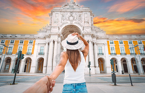 跟我来 旅游女游客手牵着男人的手在里斯本市行走 在度假的情侣图片