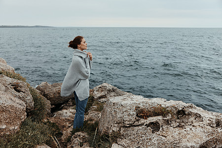 在石海岸上自由行走的美丽女性的自由 放松概念图片