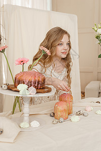长发穿轻衣服的女孩坐在复活节桌前 带蛋糕 春花和蛋 复活节庆典快乐 庆祝日 假期 鹌鹑图片