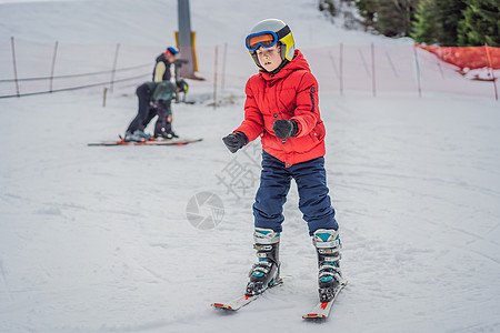 儿童在山中滑雪 带安全帽 护目镜和杆的活跃蹒跚学步的孩子 幼儿滑雪比赛 家庭的冬季运动 高山学校的孩子们滑雪课 小滑雪者在雪地里图片