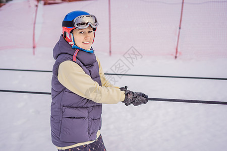 女子滑雪者爬上山顶 在滑雪电梯上为初学者 说谎 娱乐图片