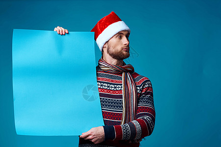 在圣诞节蓝色假造海报演播室的英俊男子图片