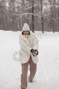 两个女孩在冬天的雪中打雪球 穿着温暖的冬衣 假期 成人图片