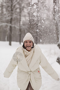 两个女孩在冬天的雪中打雪球 穿着温暖的冬衣 衣服 好玩的图片