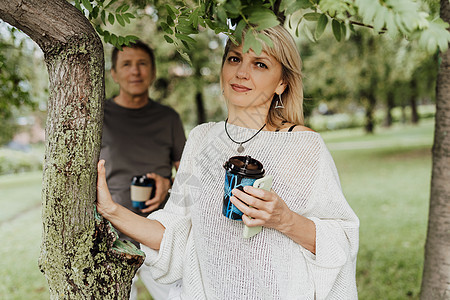 一对成年成熟幸福的情侣相爱在城市公园户外拥抱 一个金发白人男人和女人在一起喝咖啡 高级妻子和丈夫在外面散步 微笑 闲暇图片