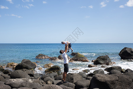 爸爸和儿子沿着海边走在海边 周末在沙滩上 海滩石头 家庭 放松图片