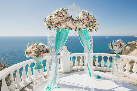 优美的婚礼拱门 鲜花 花朵 在海洋和蓝天空的背景上图片