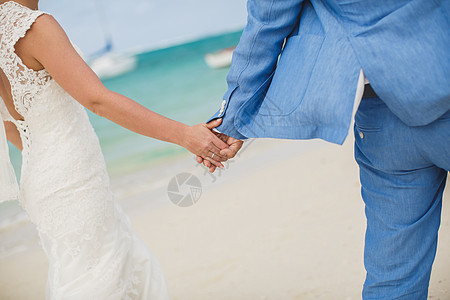 美丽的华丽新娘和时尚的新郎手牵手 在大海的背景上 支撑 男人图片