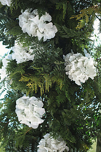 由绿色树枝和白花组成的婚礼装饰品图片