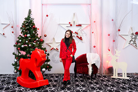 圣诞树和马背面的红色优雅淑女 新年快乐 新年快乐 假期 礼物背景图片