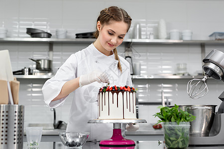 糕点厨师把蛋糕装饰成巧克力层的浆果和薄荷 礼物 桌子图片