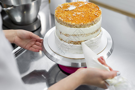 糕点厨师把蛋糕加奶油 刨冰 传播 派对 装潢 奶酪图片