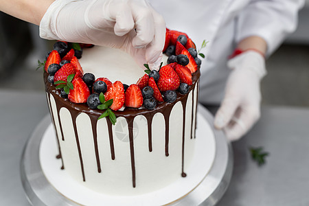 糕点厨师把蛋糕装饰成巧克力层的浆果和薄荷 甜的 派对图片