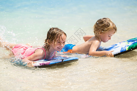 双胞胎兄妹在海中冲浪玩得开心 移动 快乐的 海洋图片