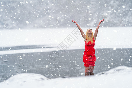 身着红裙子的年轻美女 在冬天雪冰冻湖边 女性图片