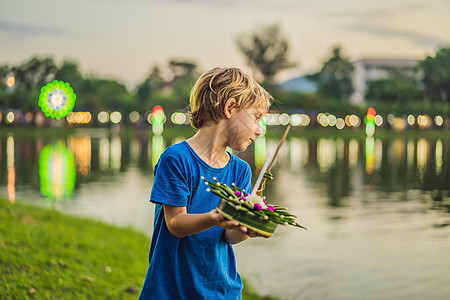 男孩游客庆祝 在水面上奔跑 节 人们购买鲜花和蜡烛点燃并漂浮在水上庆祝泰国的节图片