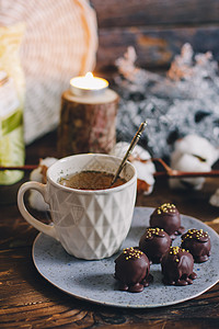 黑木背景的手工盘子上的黑巧克力手制糖果球 茶杯装在白杯中的茶 松露 牛奶图片