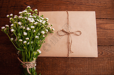 用牛皮纸做成的信封 旁边是一束洋甘菊花 放在木桌上 圣诞节 盒子图片