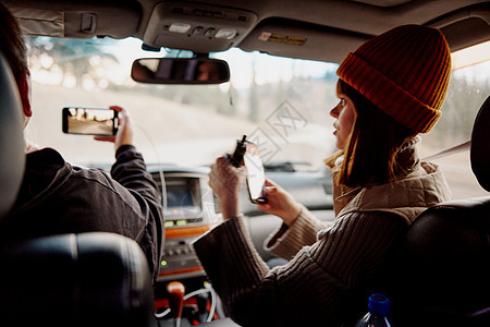 在汽车沙龙里戴帽子的女人 手里拿着电话的天性图片