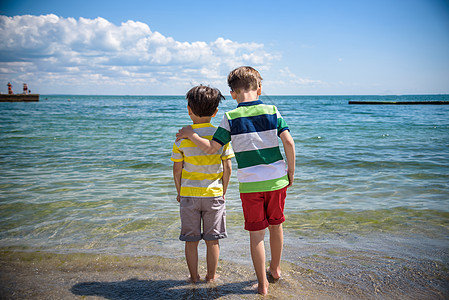 两个可爱的小孩男孩站在偏僻的海洋海滩上 孩子玩耍 看着地平线 从后面看 学龄前儿童兄弟姐妹最好的朋友在海上享受暑假 男生 快乐的图片