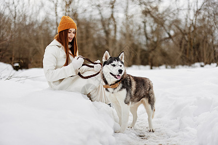 在雪中快乐的女子与狗玩 欢乐的狗友情冬假 友谊 绅士图片
