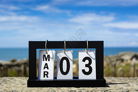 3月03日日历日期文本 在海洋背景模糊的木框上图片