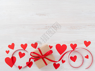 情人节的象征 — 牛皮纸棕色纸礼盒 粉红色背景上有红丝带 上面有很多红心 顶视图 文本复制空间图片