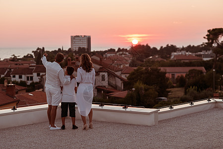 幸福的家庭在屋顶上享受和共度时光 同时一起在公海观看日落 健康 水图片