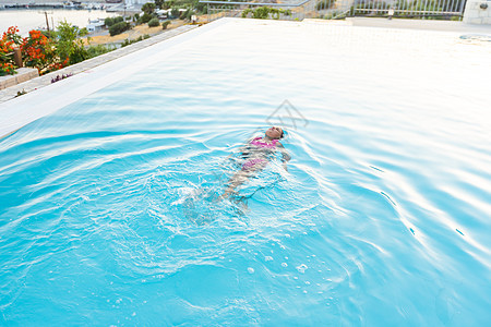 暑假在热带海滩岛上 小女孩在跳入水中的室外游泳池玩耍 儿童在豪华度假村的室外游泳池学习游泳 快乐的 戒指图片