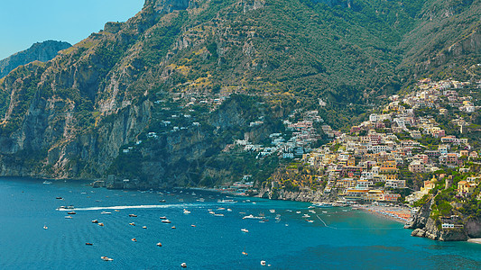 前海湾波西塔诺 Positano 是意大利最好的度假胜地之一 在陡峭的斜坡上拥有色彩缤纷的古老别墅 美丽的海滩 海港中的众多游艇和小船背景