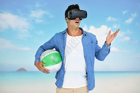 一名年轻男子戴着VR耳机 在海滩的风景上悬浮着一副脚趾头图片