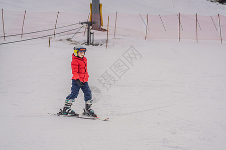 儿童在山中滑雪 带安全帽 护目镜和杆的活跃蹒跚学步的孩子 幼儿滑雪比赛 家庭的冬季运动 高山学校的孩子们滑雪课 小滑雪者在雪地里图片