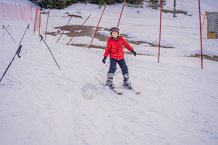 儿童在山中滑雪 带安全帽 护目镜和杆的活跃蹒跚学步的孩子 幼儿滑雪比赛 家庭的冬季运动 高山学校的孩子们滑雪课 小滑雪者在雪地里图片