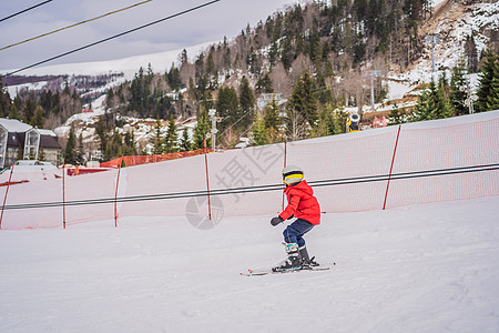 儿童在山中滑雪 带安全帽 护目镜和杆的活跃蹒跚学步的孩子 幼儿滑雪比赛 家庭的冬季运动 高山学校的孩子们滑雪课 小滑雪者在雪地里图片