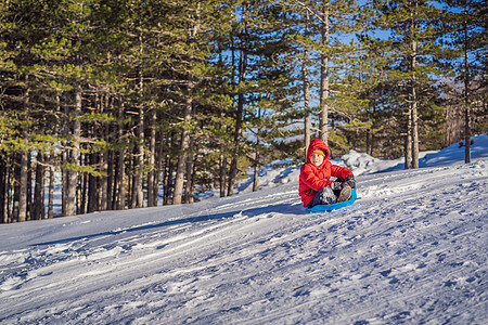 快乐和积极的小男孩享受雪橇 户外寒冷天气 冬季娱乐活动概念 游戏 旅游图片