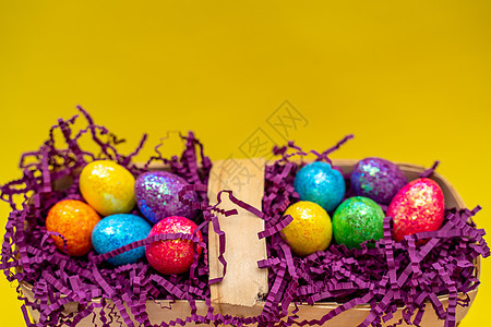 以黄色背景为假日准备的篮子和彩色鸡蛋的复活节成分组成物 花朵 传统图片