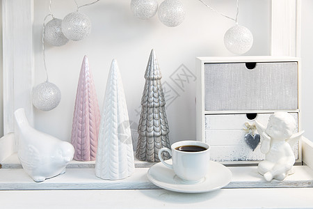 柔和色彩的圣诞树陶瓷雕像 白色彩陶天使 用线制成的球花环在圣诞节前装饰房间 糖罐图片
