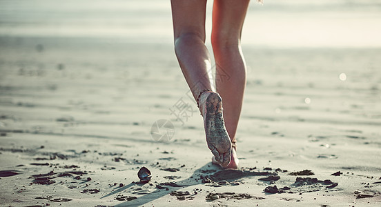 让她的脚指引着她 被一个无法辨认的女人在海滩上行走所割伤图片