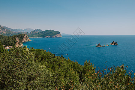 在阳光明媚的日子里 从海上欣赏岩石上如画的景色 布德瓦海滨 黑山 布德瓦岛 黑山的鸟瞰图 夏威夷海滩 遮阳伞和沐浴者以及清澈的海图片