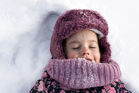 冬天 家庭 童年概念 — 特写肖像正宗的学龄前小女孩穿着粉红色的衣服微笑着闭上眼睛在寒冷的天气里躺在雪地上 有趣的孩子脸 下雪 图片