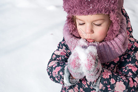 冬天 游戏 家庭 童年概念 — 特写肖像正宗的学龄前小女孩 穿着粉红色的帽子和暖和的衣服 在寒冷的天气里笑得很开心 有趣的孩子吹图片