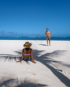 热带海滩上的男女情侣 带白色沙滩和棕榈树的热带海滩 带蓝色海洋和棕榈树的毛里求斯白色沙滩 旅行 岛图片